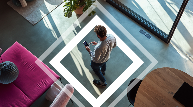 Young professional using his phone while standing in a spacious and modern office, high angle
